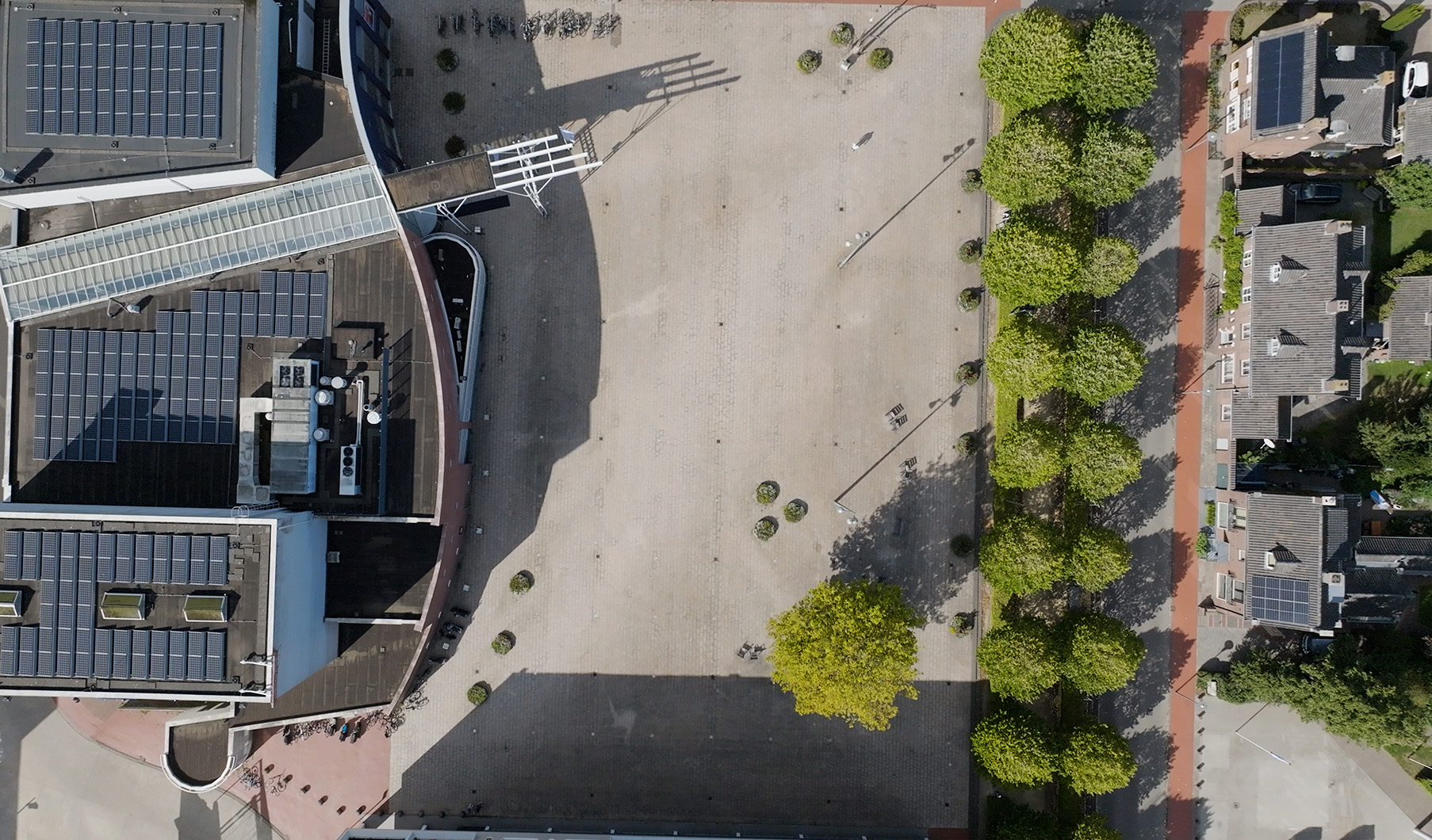 Luchtfoto huidige situatie Vredesplein Waalwijk: een versteend plein met enkele bomen